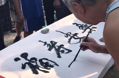 街头艺术奇景 百岁书法家挥毫传艺，三代同堂演绎文化传承
